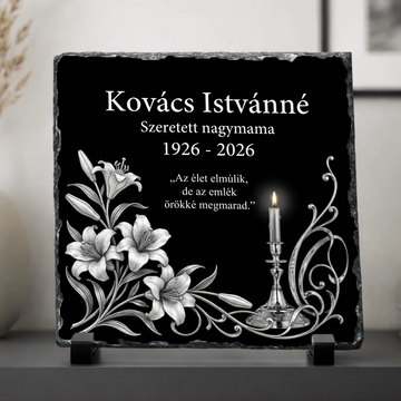 Négyzet alakú, rusztikus szélű fekete palakő emléktábla fekete műanyag talpakon. Felső részén fehér betűkkel a Kovács Istvánné Szeretett nagymama 1926-2026 felirat, középen Az élet elmúlik, de az emlék örökké megmarad idézet olvasható. Bal oldalon ezüst színű liliomok, jobb oldalon egy égő gyertya és díszes indák láthatók.