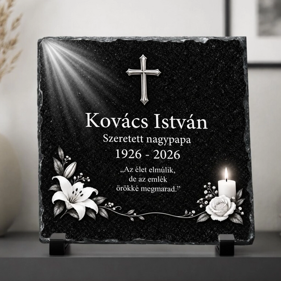 Négyzet alakú, rusztikus szélű fekete palakő emléktábla fekete műanyag talpakon. Felső részén ezüst kereszt és égi fénysugarak, alatta a Kovács István Szeretett nagypapa 1926-2026 felirat, középen Az élet elmúlik, de az emlék örökké megmarad idézet olvasható fehér betűkkel. Az alsó sarkokban fehér liliomok, egy égő gyertya és fehér rózsa látható.