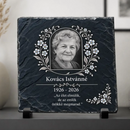Koszorú elrendezésű kék nefelejcs virágokkal és sarokdísszel díszített egyedi kegyeleti fotókő kitámasztó talpakon boltíves képkerettel és Kovács Istvánné felirattal fekete háttér előtt